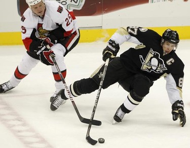 Pittsburgh Penguins' Sidney Crosby (87) loses his footing but keeps control of the puck against Ottawa Senators' Chris Neil (25) in the second period of their NHL hockey game in Pittsburgh, Pennsylvania, November 26, 2010. REUTERS/Jason Cohn