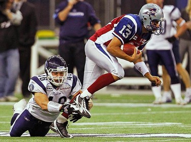 Montreal Alouettes quarterback Anthony Calvillo (R) gets away from the grasp of Toronto Argonauts Jason Pottinger during the first half of the CFL  Eastern Division final football game in Montreal, on Nov. 21, 2010.  (REUTERS)