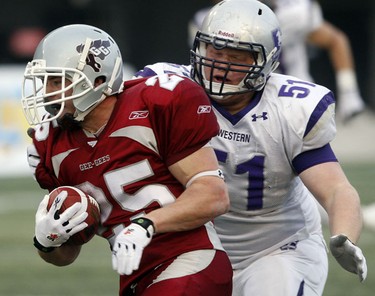 University of Ottawa GeeGees' Brendan Gillanders tries to escape the pursuit of University of Western Ontario Mustangs' Mike Van Praet (51) during the second half of the OUA Championships at Frank Clair Stadium Saturday, November 13, 2010. (Darren Brown/Ottawa Sun)