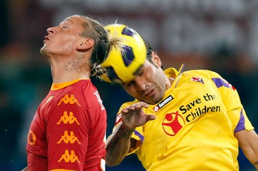 AS Roma's Philippe Mexes, left, challenges Fiorentina's Adrian Mutu during their Italian Serie A soccer match at the Olympic stadium in Rome, November 10, 2010. REUTERS/Giampiero Sposito