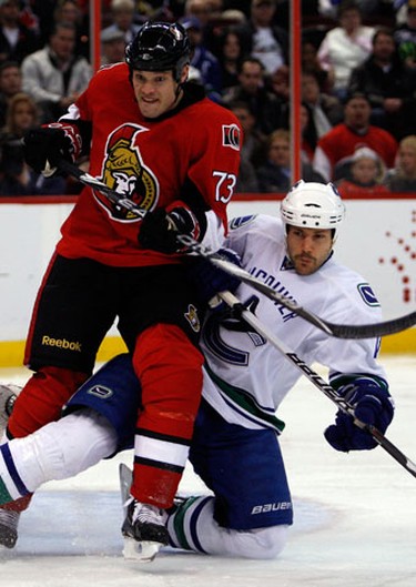 Ottawa Senators' Jarkko Ruutu (73) is hit from behind by a sliding Vancouver Canucks' Andrew Alberts (41) during the third period of NHL action at Scotiabank Place Thursday, November 11, 2010. Sens lost 6-2. (Darren Brown/Ottawa Sun)
