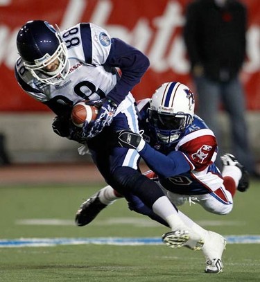 Montreal Alouettes cornerback Paul Woldu (R) tackles Toronto Argonauts receiver Mike Bradwell during the first half of CFL football action in Montreal, on Nov. 7, 2010. (REUTERS)
