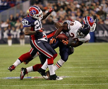 Buffalo's Donte Whitner and Arthur Moats (helmet flying off) try and strip the ball from Chicago's Chester Taylor. The Buffalo Bills and the Chicago Bears played an NFL game at the Rogers Centre in Toronto on Nov. 7, 2010. The Bears won 22-19. (CRAIG ROBERTSON, Toronto Sun)