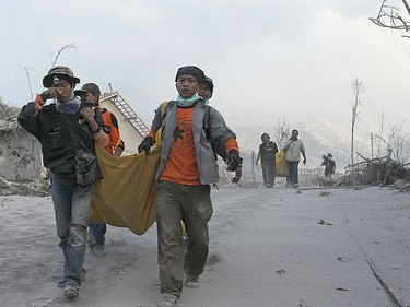 Volunteers carry the bodies of victims of the Mount Merapi eruption at Kinarrejo village in Sleman, near the ancient city of Yogyakarta October 27, 2010. (Reuters)