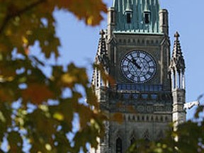 Fall colours from surrounding trees hide part of the Peace Tower on Parliament Hill, Ottawa. (Chris Roussakis/QMI Agency)