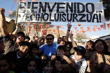 Chilean miner Luis Urzua poses with neighbours after being rescued from the San Jose mine, in Copiapo on Oct. 15, 2010. Chile's rescued miners headed home on Friday as heroes after an ordeal deep underground during which they drank oil-contaminated water and set off explosives in a desperate bid to alert rescuers. The banner reads "Welcome neighbor Luis Urzua". (REUTERS)