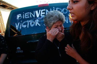 Blanca Rojas (L), mother of rescued Chilean miner Victor Segovia, reacts during his arrival to his home after being discharged from Copiapo Hospital, two days after being rescued from the San Jose mine in Copiapo on Oct. 15, 2010. The car reads "Welcome Victor". (REUTERS)