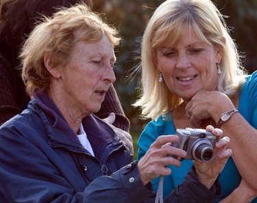 Homeowner, Colette Lessard, right, looks at pictures with Doris Veilleux. Ottawa Police tracked a moose from North Service Rd and Trim Rd in Orleans to a subdivision at Wilkie Dr. and Chenier Way in Orleans Monday, October 11, 2010. The moose stopped in the front walkway of a home before collapsing and reportedly dying of exhaustion. The homeowners were out of town and returned to see the moose removed. (Darren Brown/Ottawa Sun)