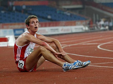 John Beattie of England sits on the track after the men's 10,000 metres finals during the Commonwealth Games at Jawaharlal Nehru Stadium in New Delhi on Oct. 11, 2010. (REUTERS)