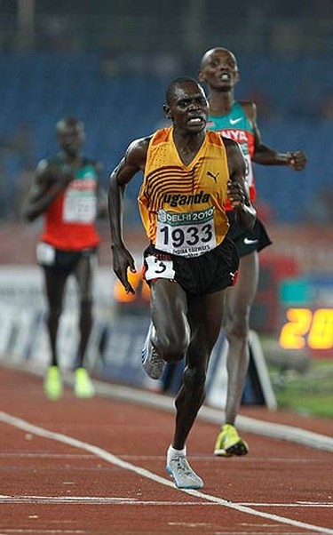 Moses Ndiema Kipsiro of Uganda crosses the finish line to win gold in the men's 10,000 metres finals during the Commonwealth Games at Jawaharlal Nehru Stadium in New Delhi on Oct. 11, 2010. (REUTERS)