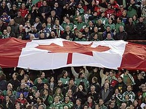 A Canadian flag is spread out during the singing of the national anthem before the 97th Grey Cup in Calgary, Alta. (Lyle Aspinall/SUN MEDIA)