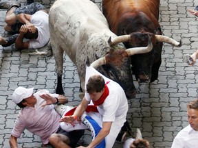 A Penajara fighting bull grabs a runner by the shirt on the first day of the running of the bulls during the San Fermin festival in Pamplona, Spain, July 7, 2010. REUTERS/Susana Vera