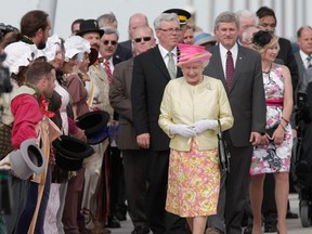 Queen Elizabeth II leads a walk on the Esplanade Riel as Premier Greg Selinger (left) and Prime Minister Stephen Harper follow. (MARCEL CRETAIN/Winnipeg Sun)