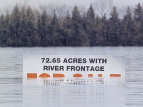 A billboard is half-submerged in water, on a field near Ste. Agathe, April 27, 1997. (TIM KROCHAK/Sun Media files)