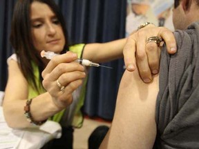 A Winnipegger gets an H1N1 flu shot at the start of the city's immunization clinics. The clinics will remain closed until Thursday. (SUN MEDIA)