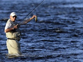 Mats Striegler holds up a small bass while fishing near the Remic Rapids on the Ottawa River Tuesday, August 11, 2009. (DARREN BROWN/Sun Media)