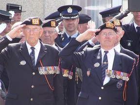 War veterans salute during a D-Day ceremony in Normandy, France in this 2009 photo. Manitoba vets will receive free on-street metered parking on D-Day this year, provided they have a veterans' licence plate on their vehicle. (KATHLEEN HARRIS/SUN MEDIA)