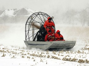 Rescuers travel on an airboat over an icy cornfield on their way to check on flood-threatened home owners in the Oxbow housing development near the Red River, south of Fargo, in 2009. Things may not be that much better south of the border — or north — this year, say flood forecasters. (REUTERS/Eric Miller)