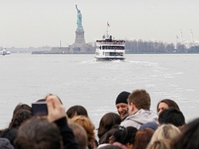 Crowds of tourists wait for the ferry to Liberty Island to see the Statue of Liberty and Ellis Island in New York, April 8, 2011. The White House and Congress have until midnight on Friday to agree to a budget bill or there will be a partial shutdown of the U.S. government. National parks, national forests and the Smithsonian Institution in Washington would close. (REUTERS/Brendan McDermid)