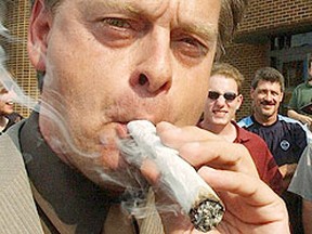 Marc Emery lights up a marijuana cigarette in front of the London Ontario police headquarters in this Aug. 26, 2003 file photo. (Morris Lamont, QMI Agency)