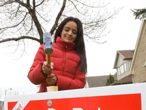 Liberal MP Ruby Dhalla hammers an election sign into the front lawn of a constituent in her riding of Brampton-Springdale. (Mark O'Neill/QMI Agency)