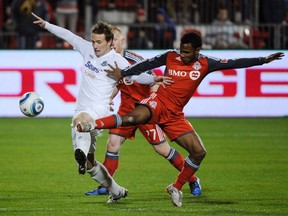 FC Edmonton Paul Craig battles for the ball with Toronto FC's Julian de Guzman (R) and Richard Eckersley (C) during the second half of their Nutrilite Canadian Championship soccer game Wednesday in Toronto. De Guzman is hurt again, but will likely start against the Houston Dynamo Saturday at BMO Field.  (REUTERS/Mark Blinch)