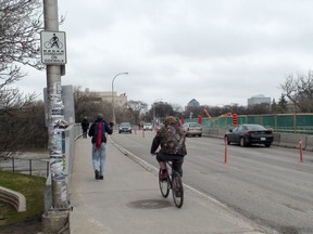 A cyclist rides his bike across the Osborne Bridge Tuesday, apparently ignoring a sign advising people to dismount. Police were at the foot of the bridge Tuesday morning ticketing cyclists for such behaviour. (Paul Turenne, Winnipeg Sun)