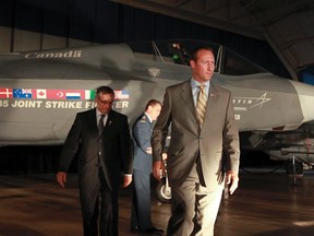 Defence Minister Peter MacKay, right, and MP Tony Clement walk past the Lockheed Martin Joint Strike Fighter F-35 Lighting II. (ANDRE FORGET/QMI Agency Files)