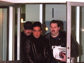 A handcuffed Joe Bravo is escorted by RCMP officers in 2001 in Woodbridge. (MIKE CASSESE/Toronto Sun files)