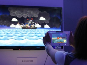 An assistant demonstrates the use of the new Nintendo Wii U controller during the Electronic Entertainment Expo, or E3, in Los Angeles June 7, 2011. REUTERS/Mario Anzuoni