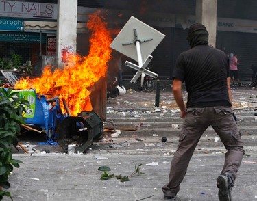 A protester throws a table at a fire in Athens' central Syntagma (Constitution) Square June 15, 2011 during clashes. REUTERS/Yannis Behrakis