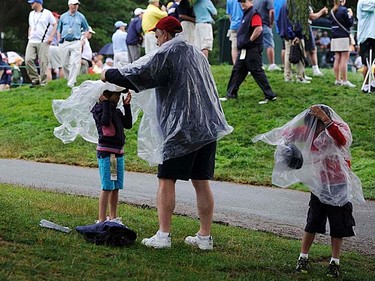 Spectators put on rain gear as rain falls during first round play at the 2011 U.S. Open at Congressional Country Club in Bethesda, Maryland, Thursday, June 16, 2011. (REUTERS/Jonathan Ernst)