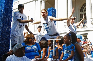 Dallas Mavericks power forward Dirk Nowitzki (C) mimics teammate shooting guard Jason Terry (L) by impersonating his 'jet on the runway' gesture as point guard Jason Kidd waves to fans as they ride on a float during a parade to celebrate their NBA championship in Dallas, Texas June 16, 2011. Dallas defeated the Miami Heat to win the 2011 NBA title. (REUTERS)
