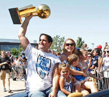 Dallas Mavericks owner Mark Cuban holds the championship trophy as he rides in a car with his family during a parade to celebrate their NBA championship in Dallas, Texas June 16, 2011.  Dallas defeated the Miami Heat to win the 2011 NBA title. (REUTERS)