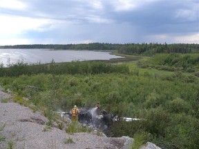 Emergency crews douse a fire on an aircraft following a crash in Pukatawagan on Monday, July 4, 2011. One man died in the crash. (Handout)