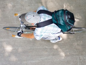 A cyclist without a helmet pedals through Ivey Park in London, Ont. (DEREK RUTTAN, QMI Agency)