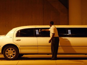 A limousine driver wipes dust from his limo outside Sky Harbor International Airport during a dust storm in Phoenix, July 5, 2011. Visibility was reduced to zero in some areas as wind gust blew near 40 miles per hour, local media reported on Tuesday. REUTERS/Joshua Lott