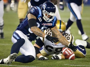 Toronto Argonauts Ricky Foley recovers a fumble by Winnipeg Blue Bomber Fred Reid in the first quarter of their CFL football game in Toronto Saturday. Foley was fined by the CFL for comments he made after the contest. (REUTERS/Fred Thornhill)