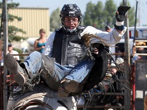 Ty Pozzobon gets thrown from "Stunting Like My Daddy" the bull during the final day of the Bulls for Breakfast at the Big Valley Jamboree in Camrose, AB on July 31, 2011. LAURA PEDERSEN/EDMONTON SUN QMI AGENCY