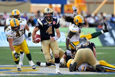 Winnipeg Blue Bombers' quarterback Buck Pierce (4) runs past Edmonton Eskimos defenders on his way to a touchdown during the first half of their CFL game in Winnipeg, August 5, 2011. REUTERS/Fred Greenslade (CANADA - Tags: SPORT FOOTBALL)