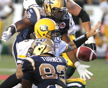 Edmonton Eskimos quarterback Ricky Ray (c) loses the ball while being sacked by Winnipeg Blue Bombers line backer Fernand Kashama (56) and defensive tackle Bryant Turner during fourth quarter CFL action in Winnipeg Friday August 05. 2011.
BRIAN DONOGH/WINNIPEG SUN/QMI AGENCY