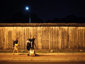 Backpackers walk along the remains of the former Berlin Wall at the Berlin Wall memorial site in Bernauer Strasse, August 3, 2011. REUTERS/Fabrizio Bensch