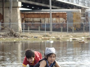Kids circumnavigate a giant puddle near the Arlington Bridge. Now that you know the overpass is closing for a week, you may be able to avoid taking the same route. (Winnipeg Sun files)