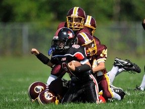 A pack of Nepean Redskins players tackle a Myers Riders opponent during a NCAFA minor football game. The Redskins are the subject of a human rights complaint over the team's name. (File photo JOHN MIELKE/NCAFA)