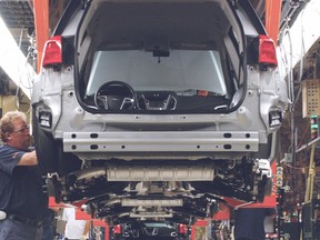 Cami employees works on a vehicle in this 2009 file photo. (QMI Agency)