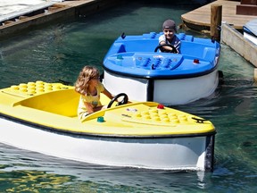 Jadyn Fernandez (L), 9, and Alex Fernandez, 10, captain their Lego boats at the Boating School ride at Legoland Florida during its grand opening celebration in Winter Haven, Florida October 14, 2011. A symbolic 50 millionth Lego brick was snapped in place on Friday on a giant red octopus at Legoland Florida, as the theme park -- the fifth and largest Legoland in the world -- prepares to open to the public this weekend southwest of Orlando. REUTERS/Pierre DuCharme