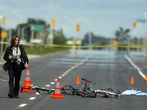 An Ottawa Police photographer walks away from two wrecked bicycles and scattered debris from a hit-and-run over 120M of March Rd in which five cyclists were seriously injured Sunday, July 19, 2009. (DARREN BROWN/Sun Media)