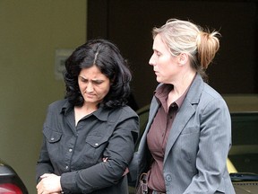 Tooba Mohammad Yahya (left) is escorted by a police officer Kingston, Ont. She is accused of four counts of first-degree murder. (QMI Agency File)