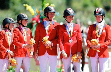 Canada's equestrian team, (L-R) Hawley Bannett, Jessica Phoenix, James Atkinson, Rebecca Howard and Selena O'Hanlon, stands on the podium after winning the equestrian Team Rider silver medal at the Pan American Games in Mexico on Oct. 23, 2011. (REUTERS)