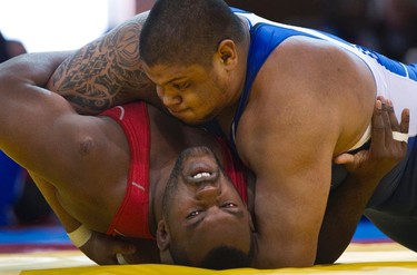Canada's Sunny Dhinsa (top) pins Carlos Feliz Garcia, of the Dominican Republic, to the mat during their men's 120kg wrestling match at the Pan American Games in Mexico on Oct. 23, 2011. (REUTERS)